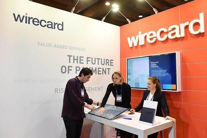 three employees standing at a wirecard display booth at the Web Summit conference