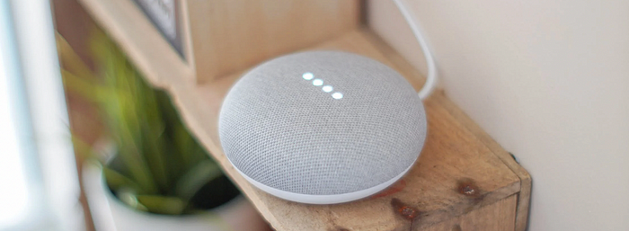 A Google Home with the lights on.