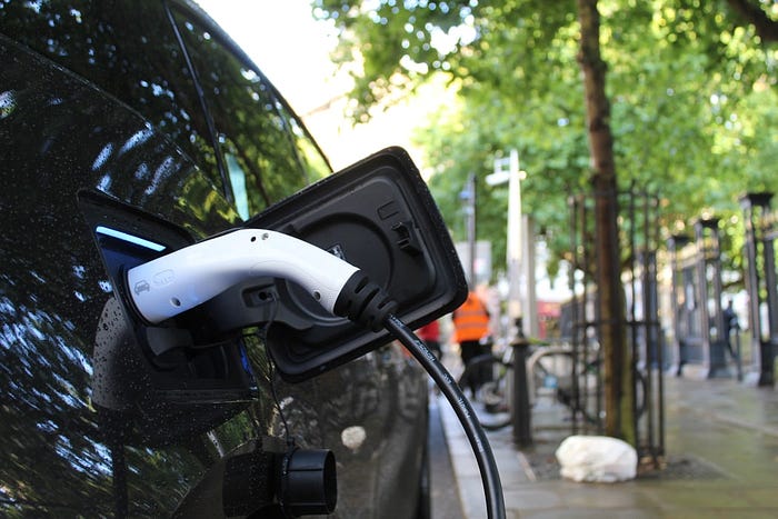 Electric car being charged at public charge point, UK