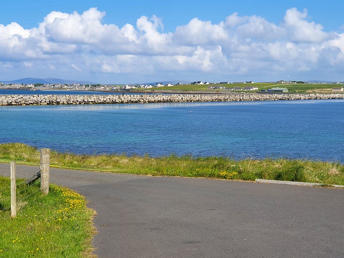 Wall of stones across an expanse of seawater.