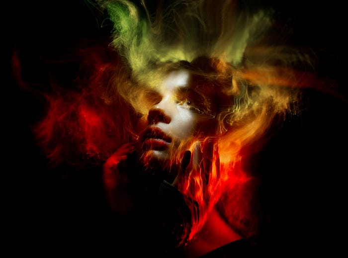 Photo by Sergey Katyshkin from Pexels showing a face against a black background mostly obscured by airbrushed colors of red, orange, green and yellow.