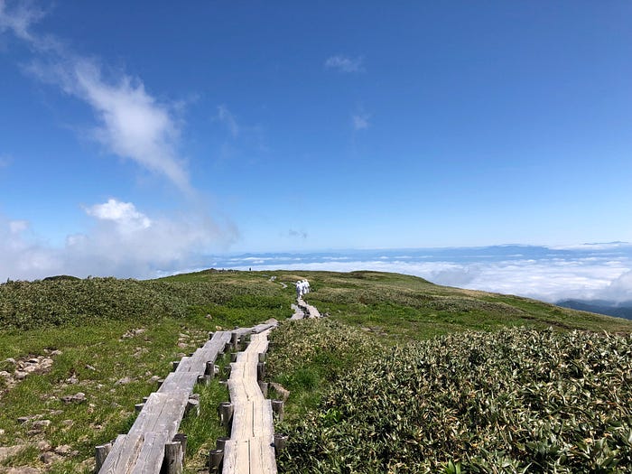 Wooden planks line the path up Mt. Gassan of the Dewa Sanzan that rises above the clouds