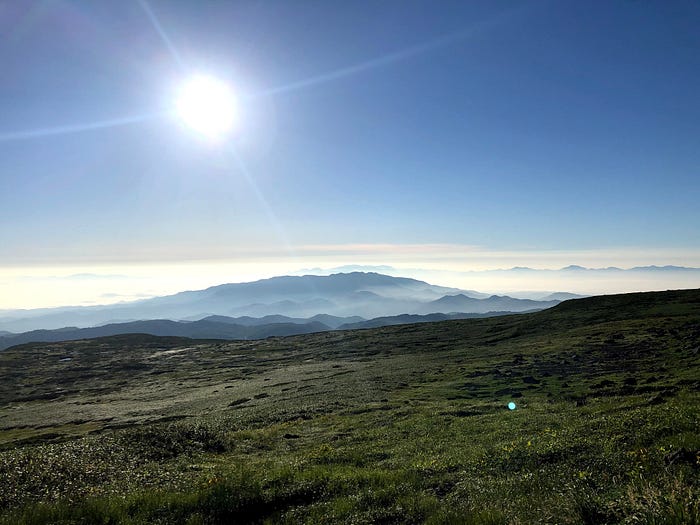 The sun shines bright over the mountains near Mt. Gassan of the Dewa Sanzan covered in a sea of clouds.