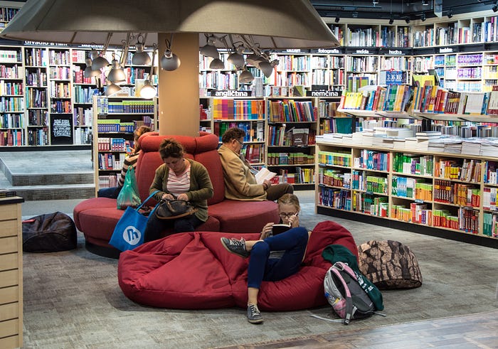Several people reading books inside a library
