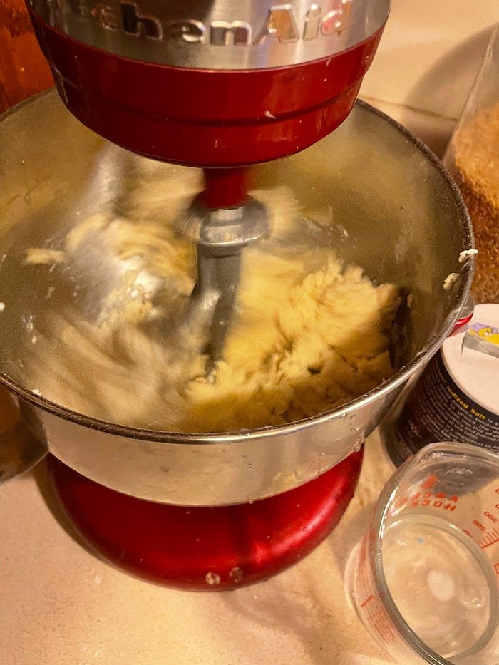 A close up of a mixer, mixing dough.