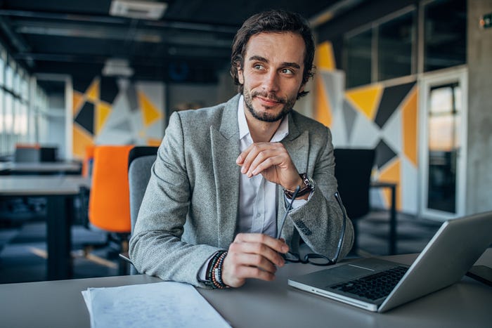 Man at office smiling at his computer.