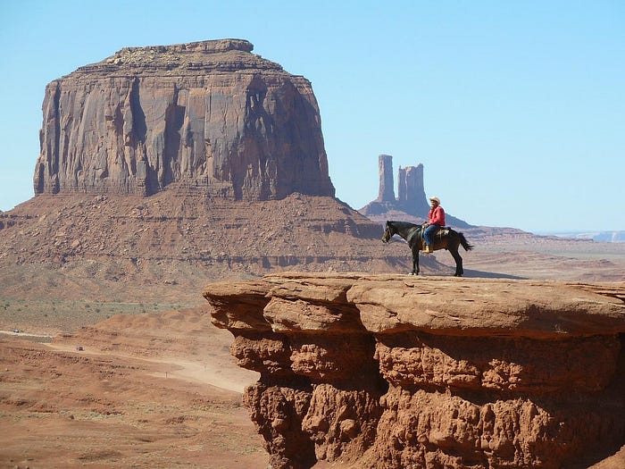 Man on horse on a butte in Monument Valley.