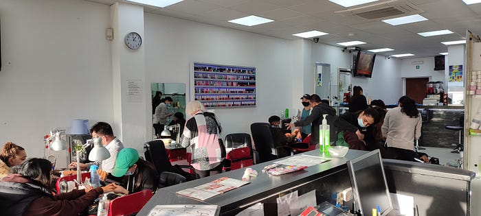 Picture inside a haidresser bussiness with women from different ethnics doing their nails.