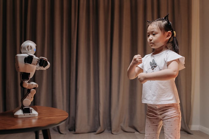 A young girl imitating the movements of a robot