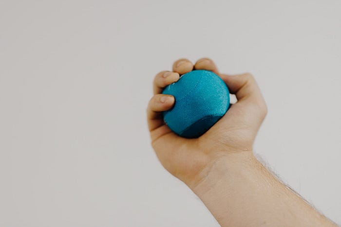 Why Is A Black Hole Really So Special? - An image of a person squeezing a sponge ball with their hand.