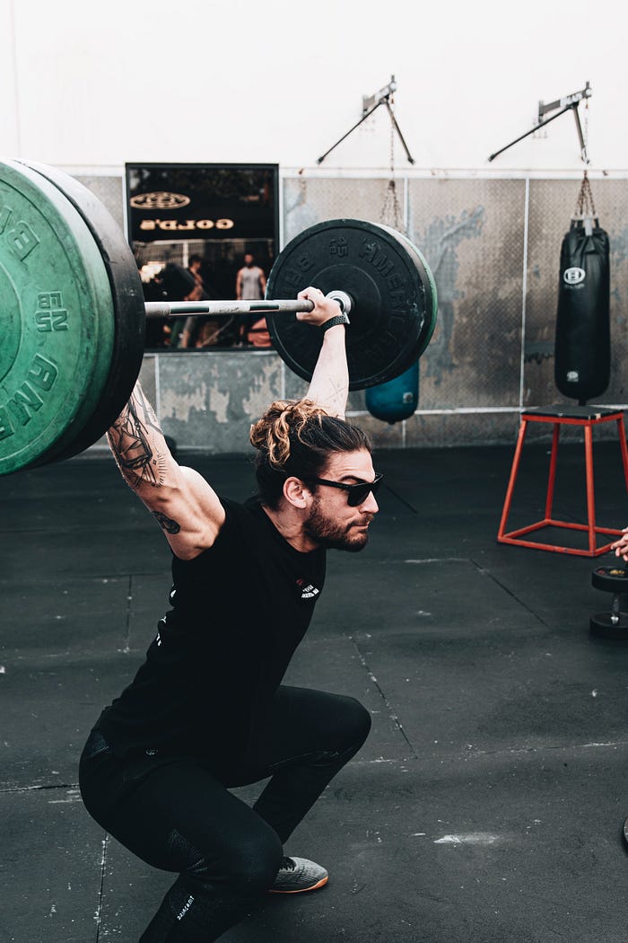 Strong man exercising doing a full clean squat