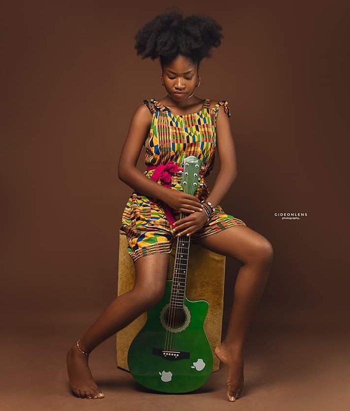 black woman with natural hair holding a guitar, black women and  music