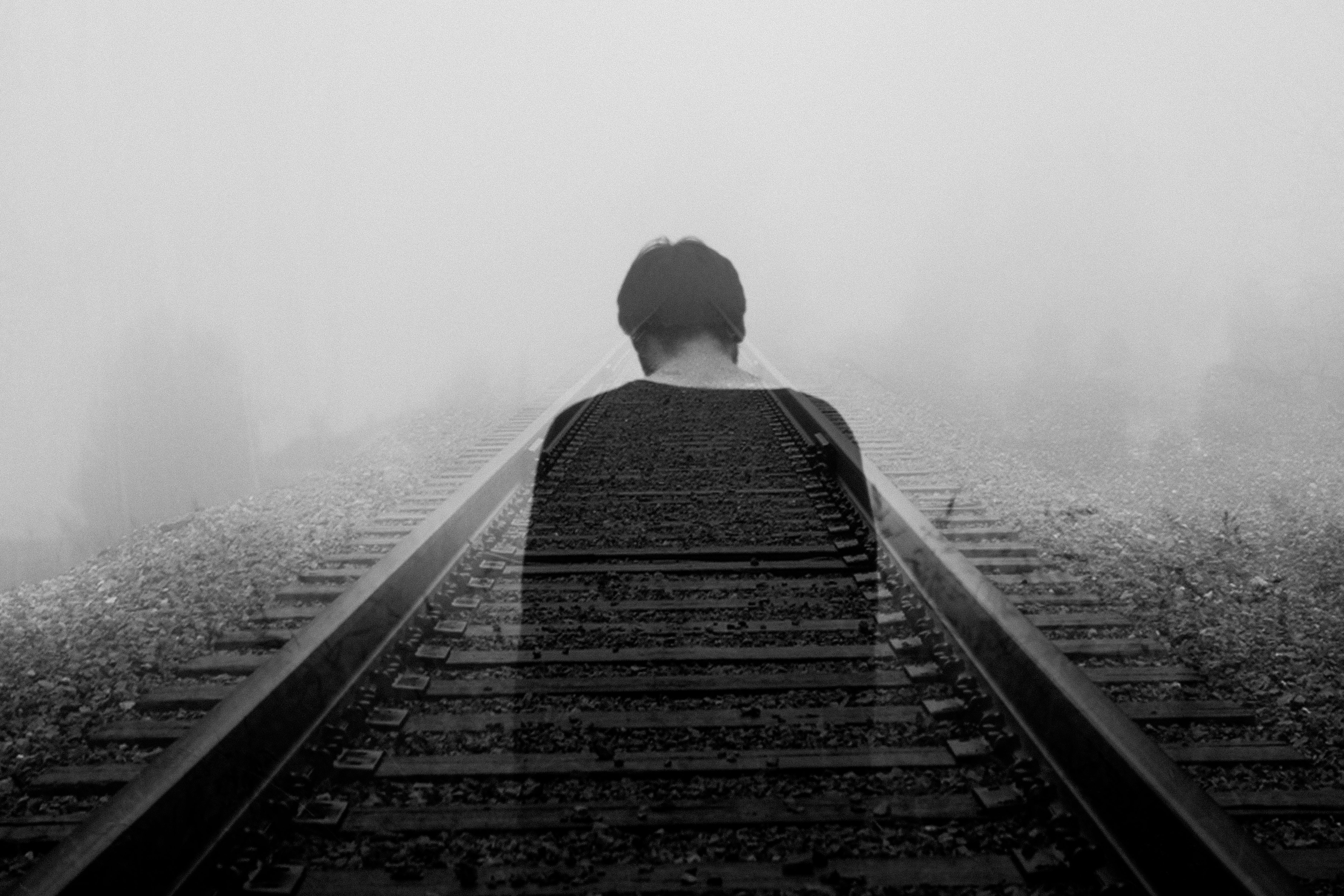 ghostly image of man walking down railroad tracks feeling as if he has lost everything