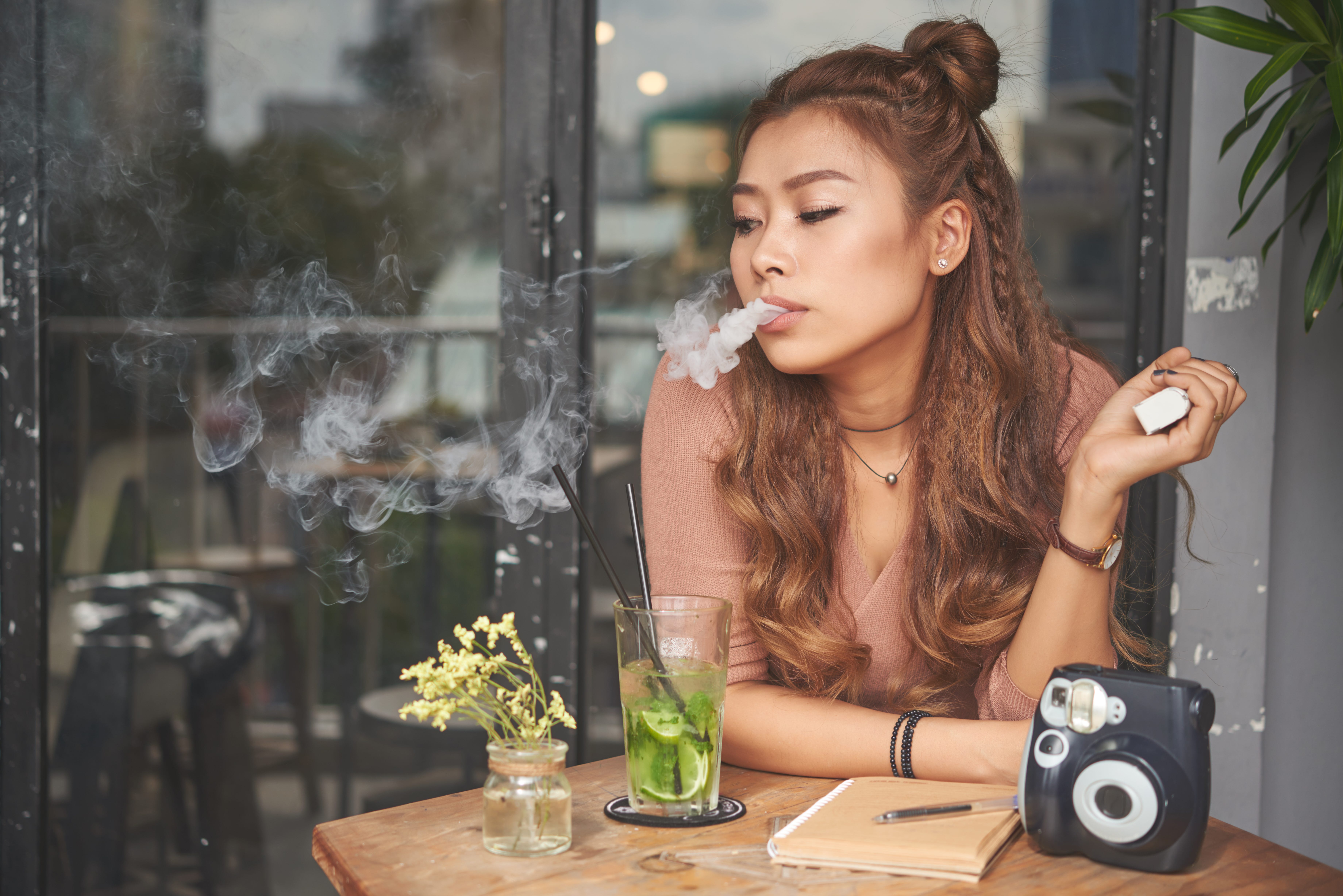 A young woman smoking an electronic cigarette.