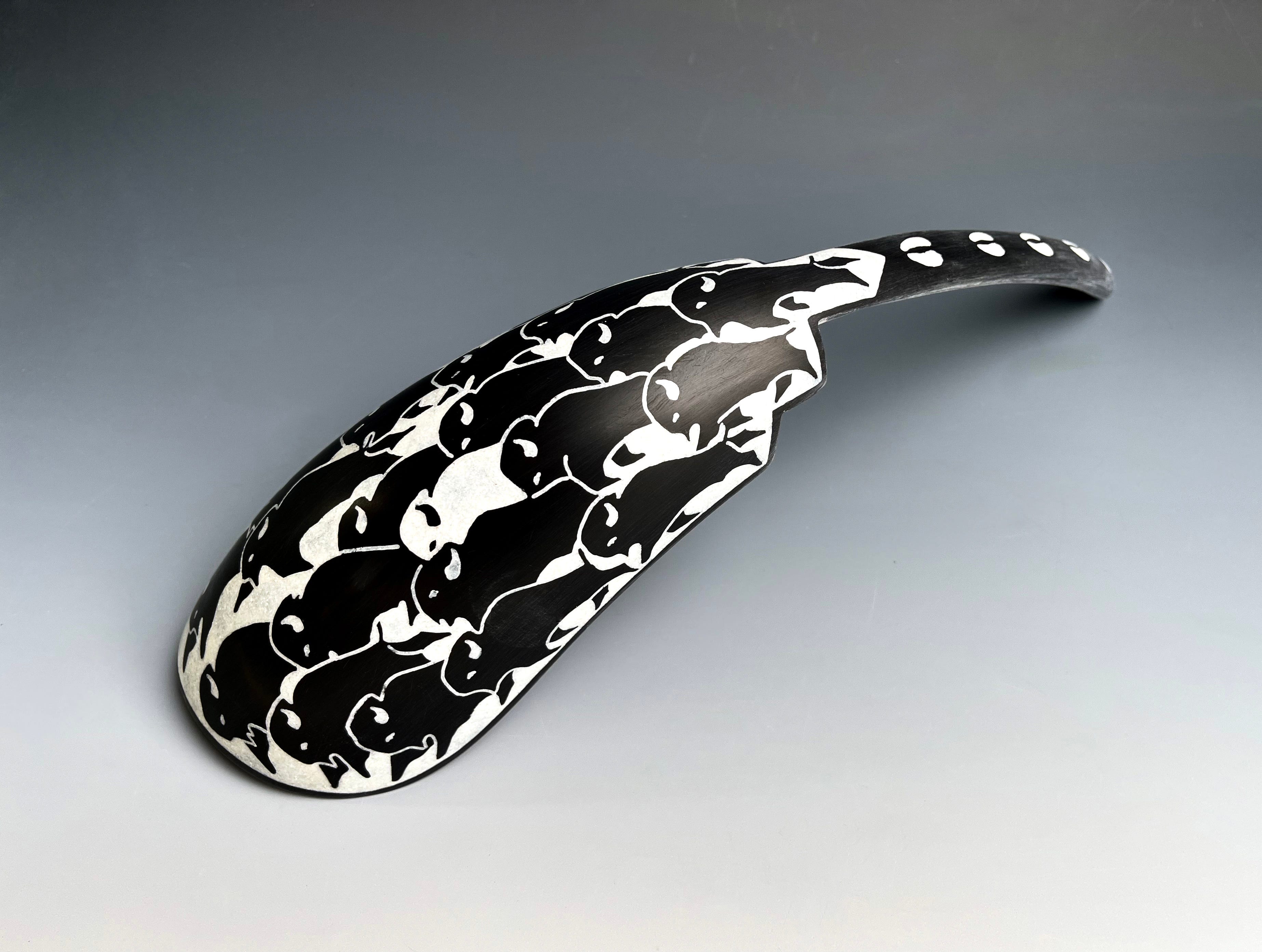 A spoon covered in black and white bison