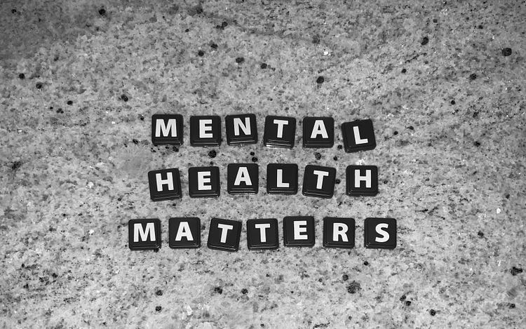 black squares with white lettering spell out in three lines, top to bottom, mental health matters against gray marble background