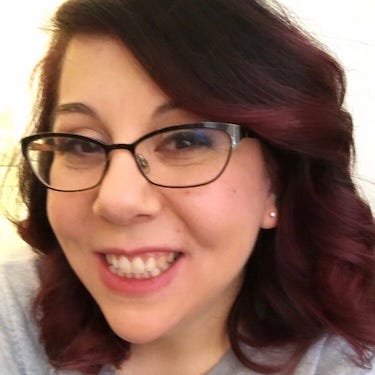 A picture of my face, smiling, with brunette hair and makeup done flawlessly.