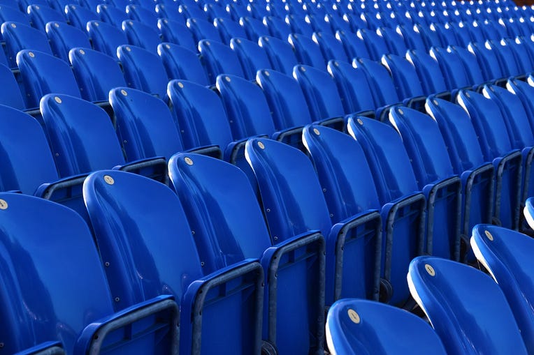 Row of empty blue stadium seats.