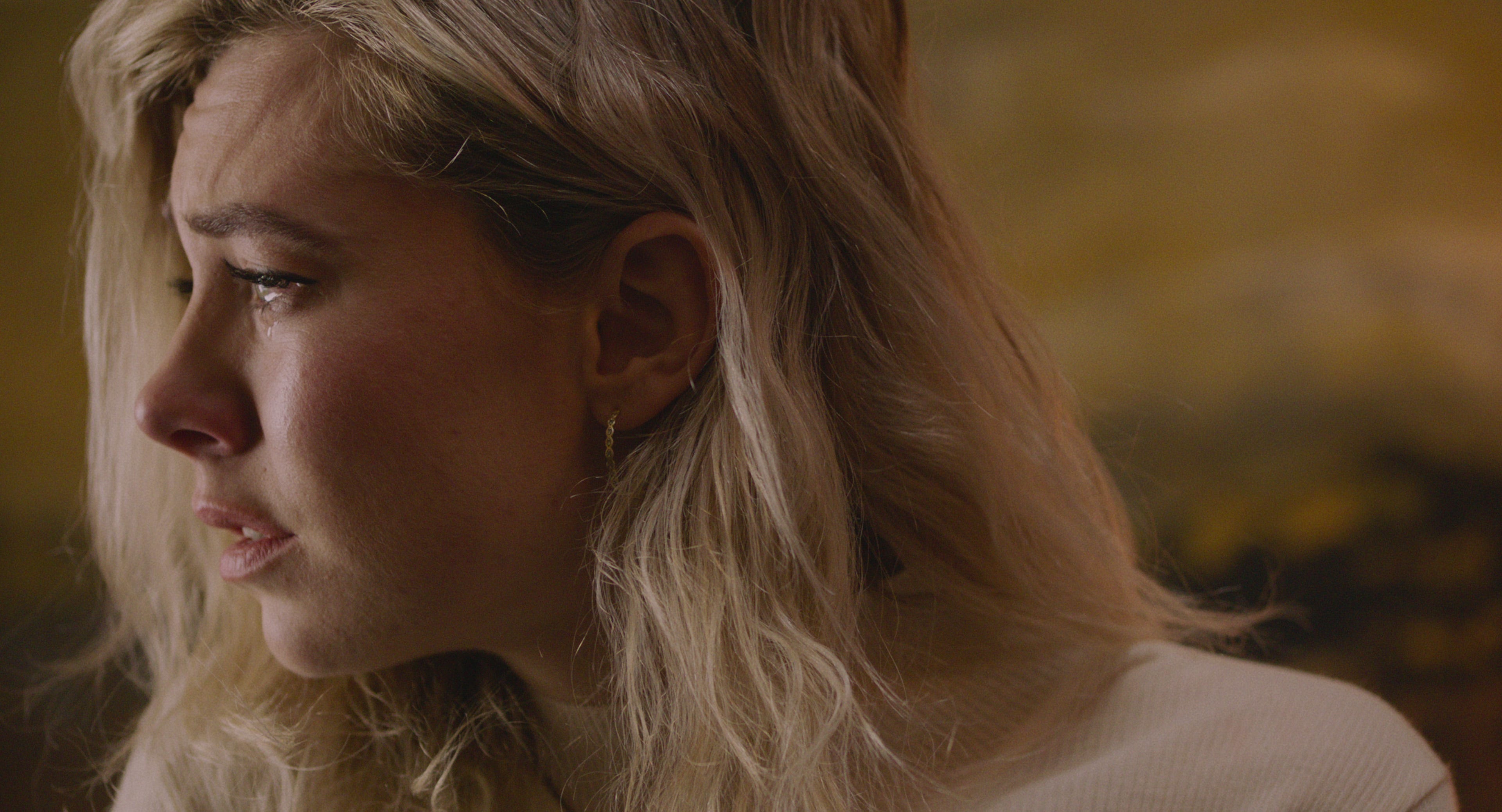 Martha looks to her right with a tear in her eye.