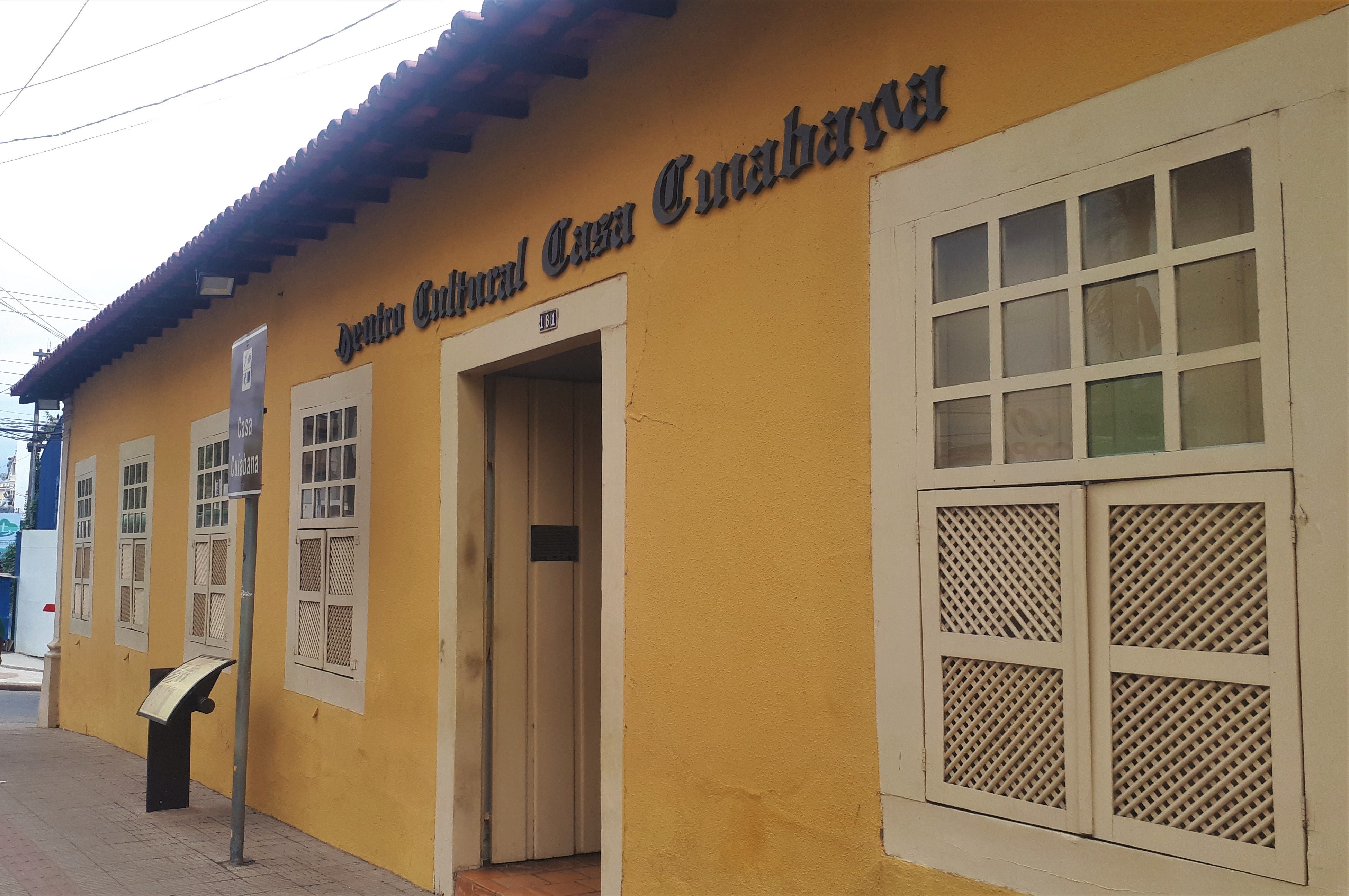 Centro Cultural Casa Cuiabana, localizado na Avenida General Valle, 181, esquina com a Travessa Frei Ambrósio no bairro Bandeirantes, próximo ao centro.