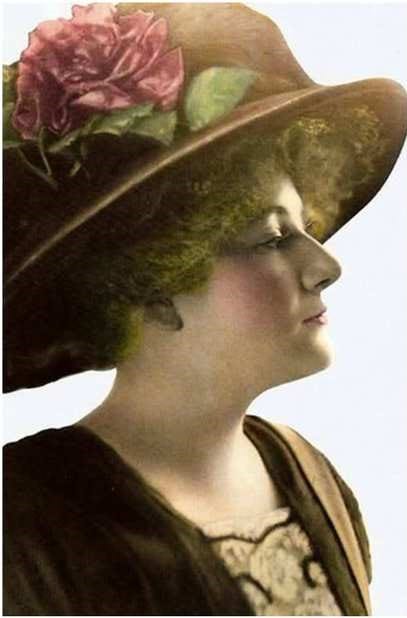 A portrait of a woman wearing a fancy early 1900s hat and outfit
