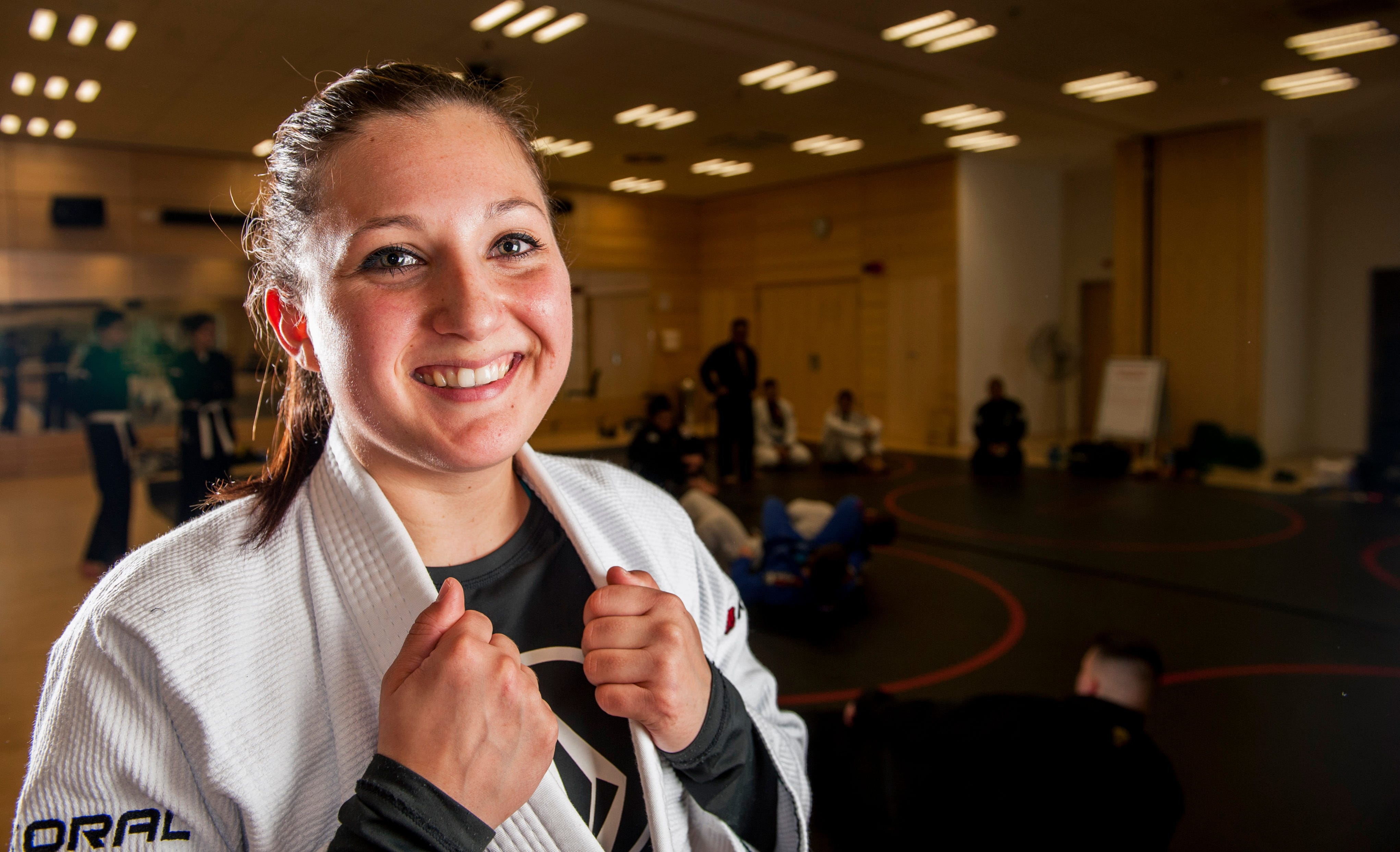 A happy female BJJ fighter posing for a photo