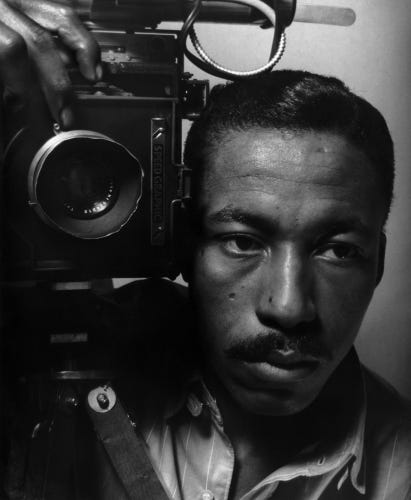 Young Gordon Parks holding a large format camra on his shoulder