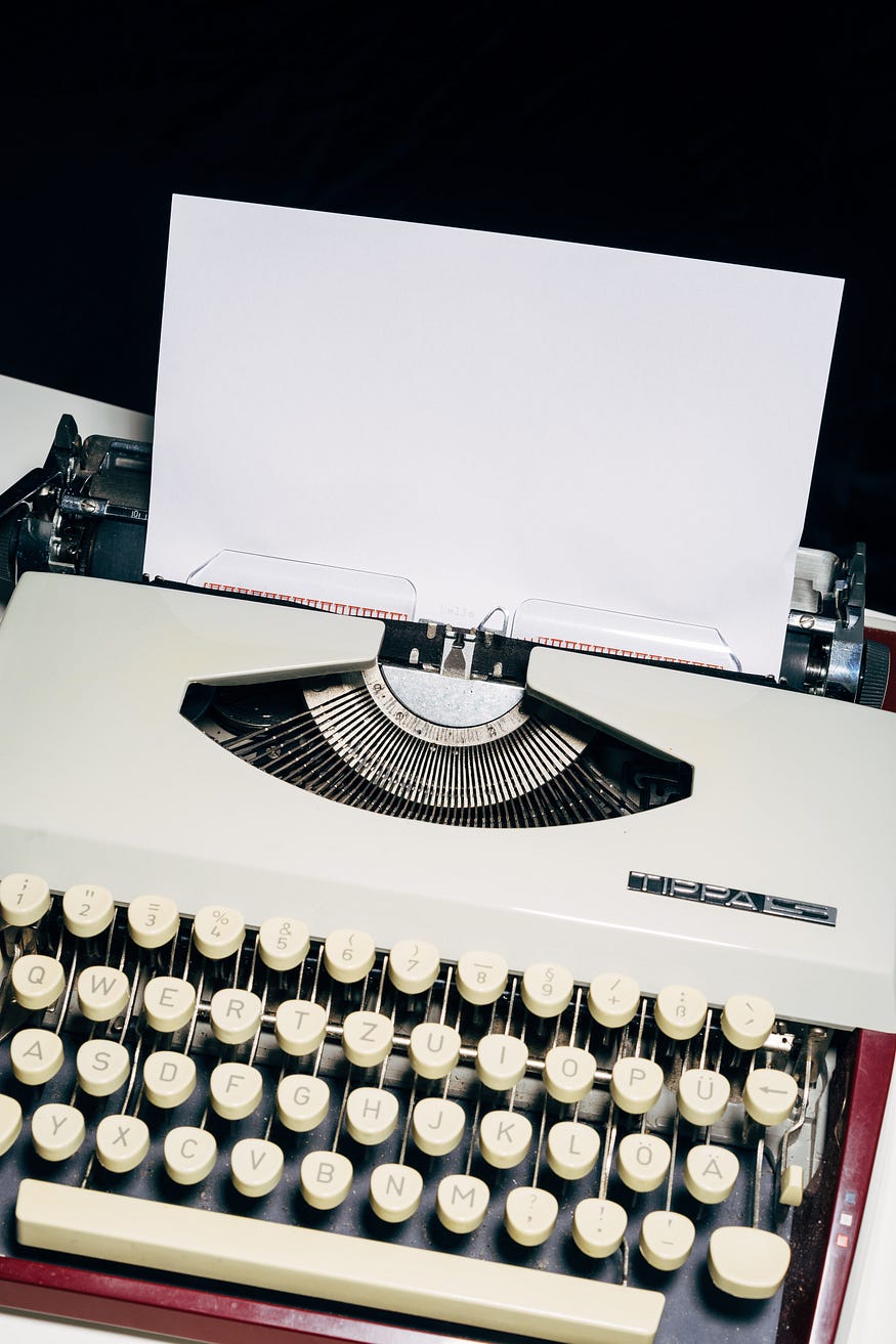 vintage typewriter with blank sheet of paper in it