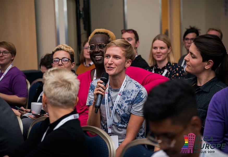 A participant in the audience makes a question to the speakers.