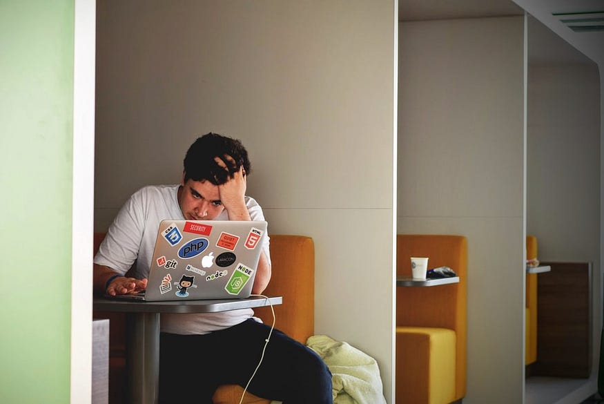 a man appears to be worried and stressed while looking at his laptop