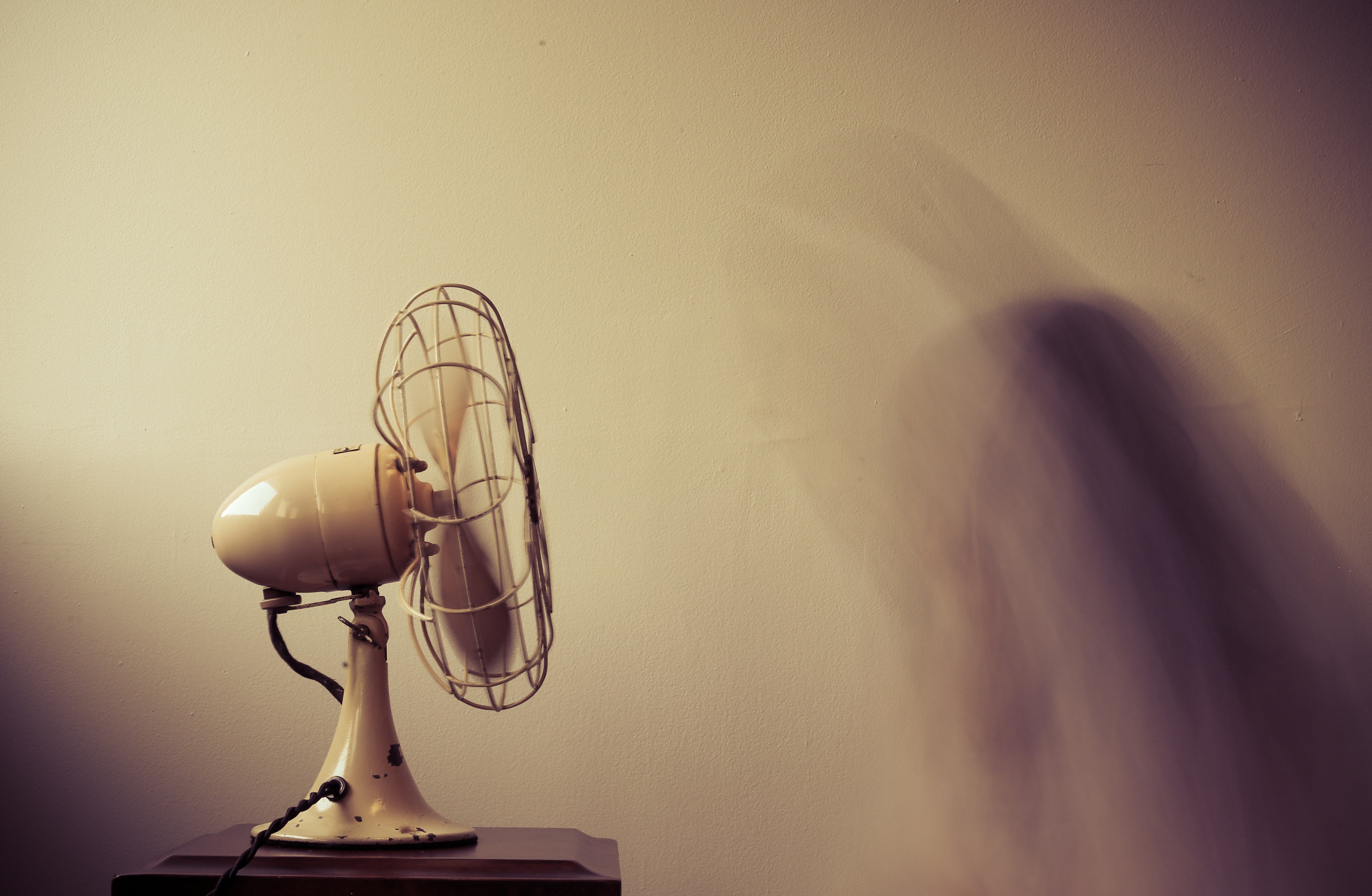Fan blowing with a blurred image of a person.