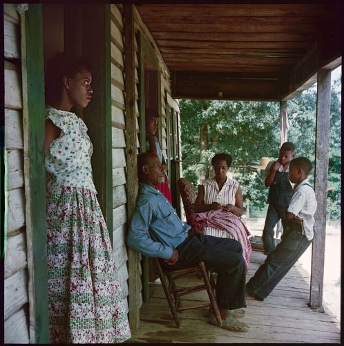 African American family sitting and standing on their front porch in the segreated south