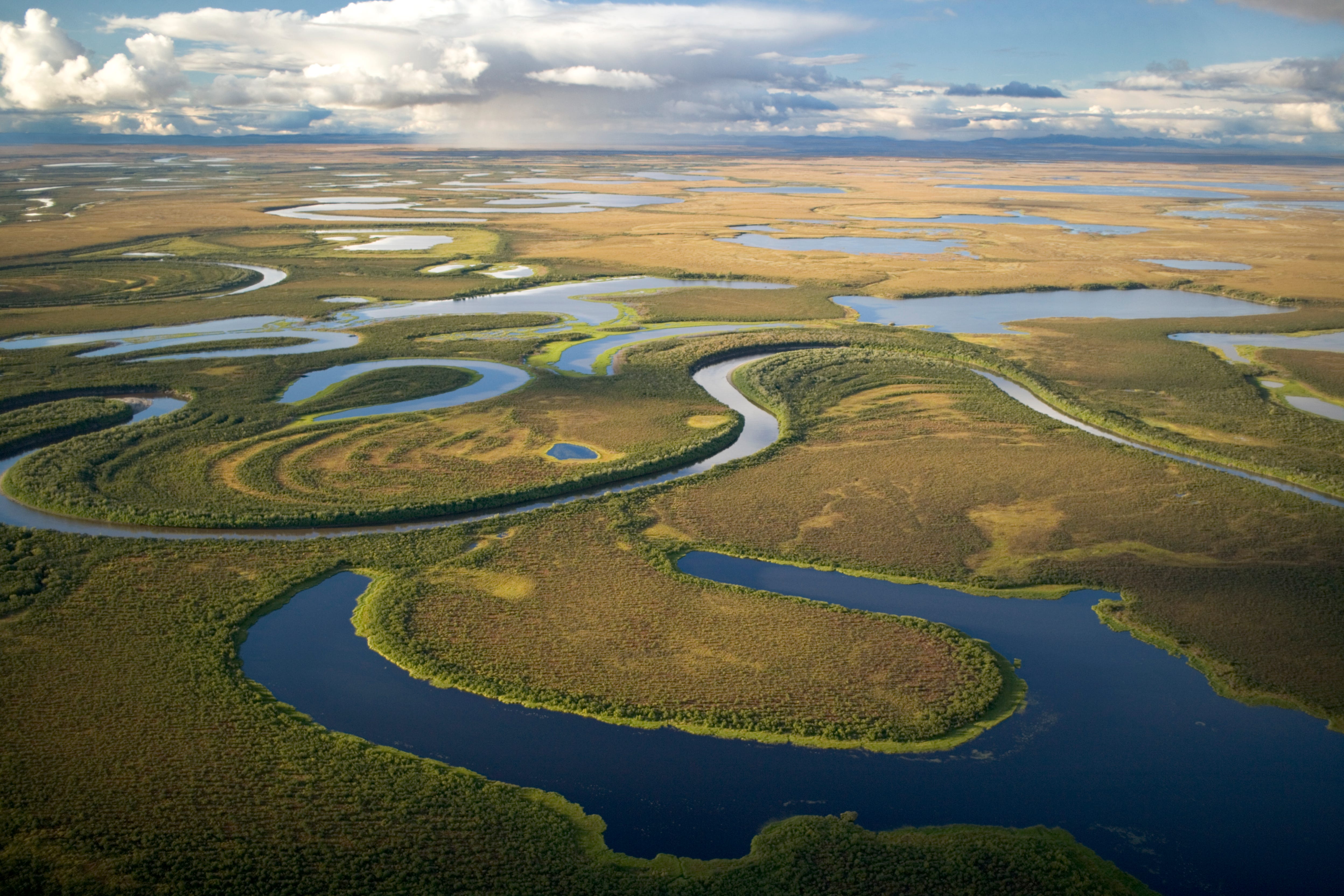 windy river and oxbows with clouds and mountains in the background
