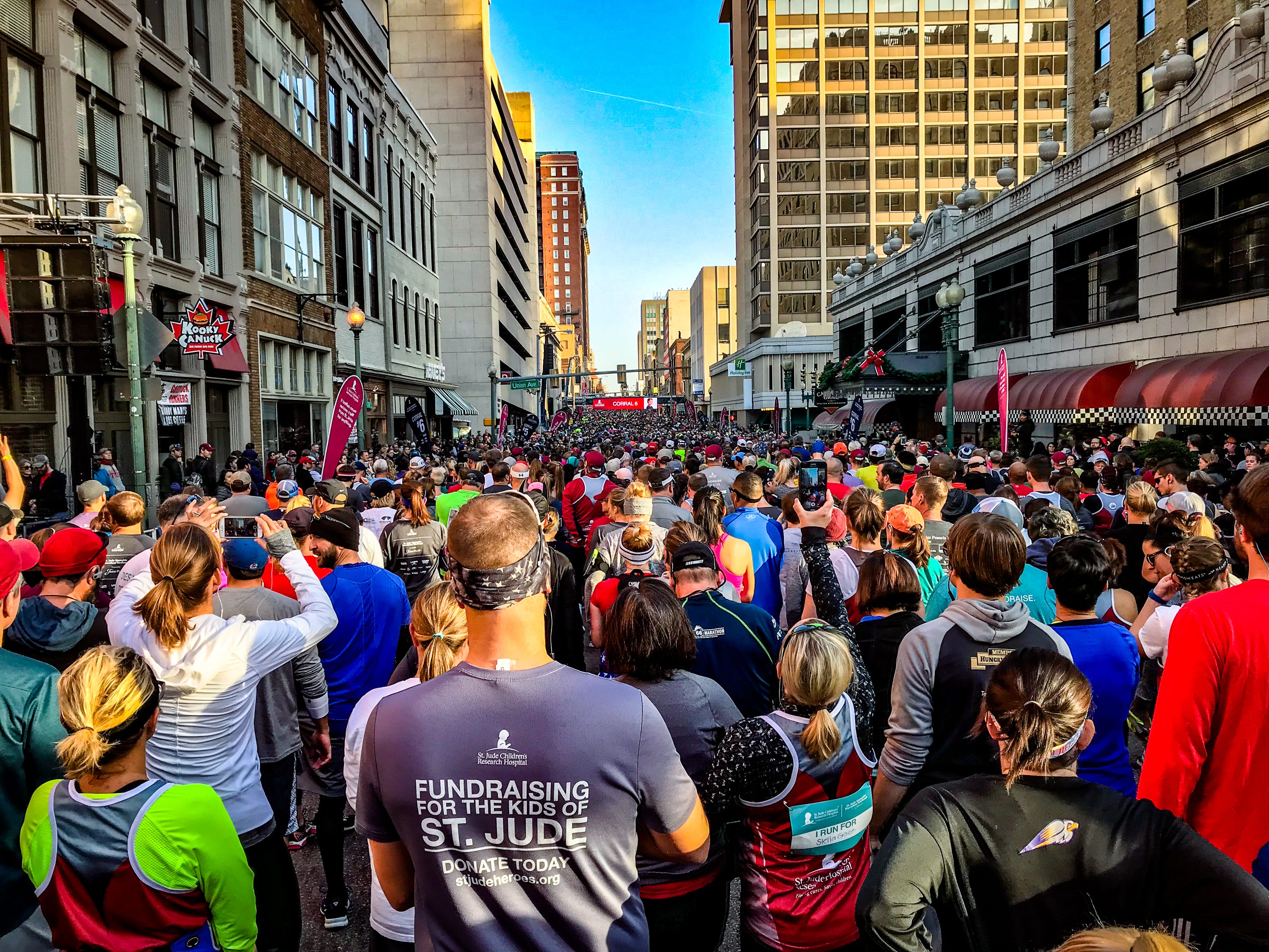 Lots of runners lined up in a street ready to begin a big foot race