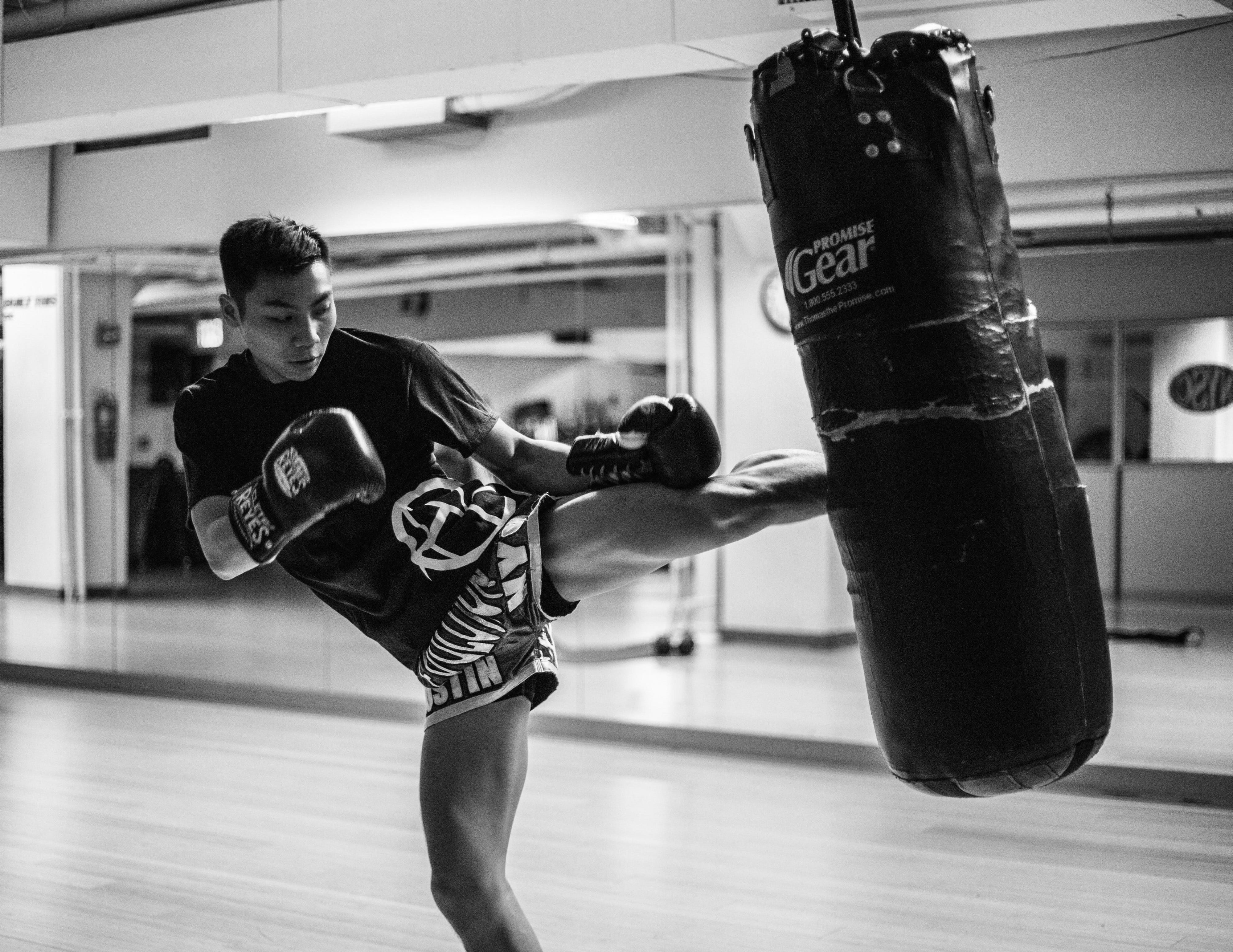 Kickboxer roundhouse kicking heavy bag