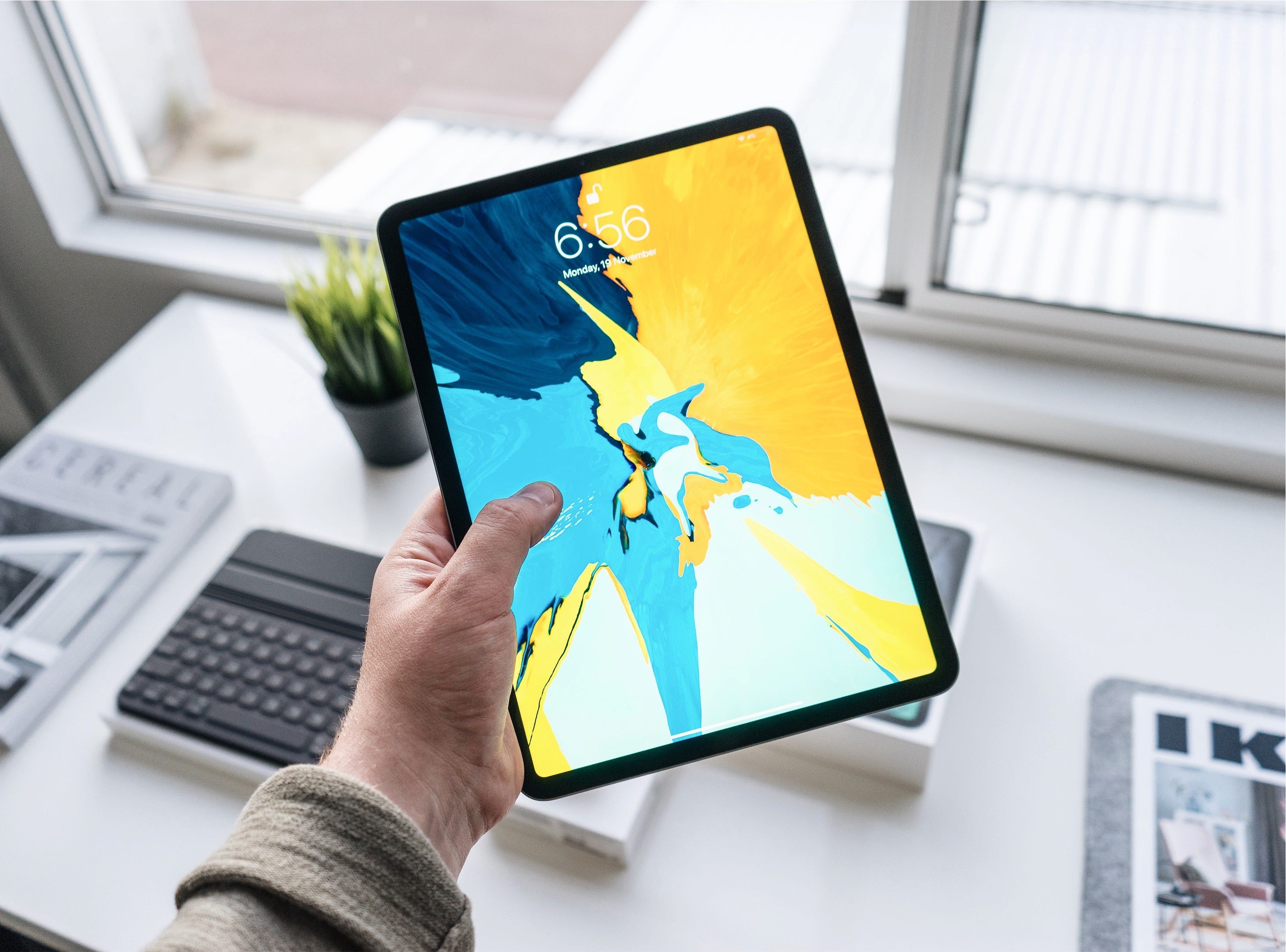 someone holding up an iPad with an abstract illustration displayed