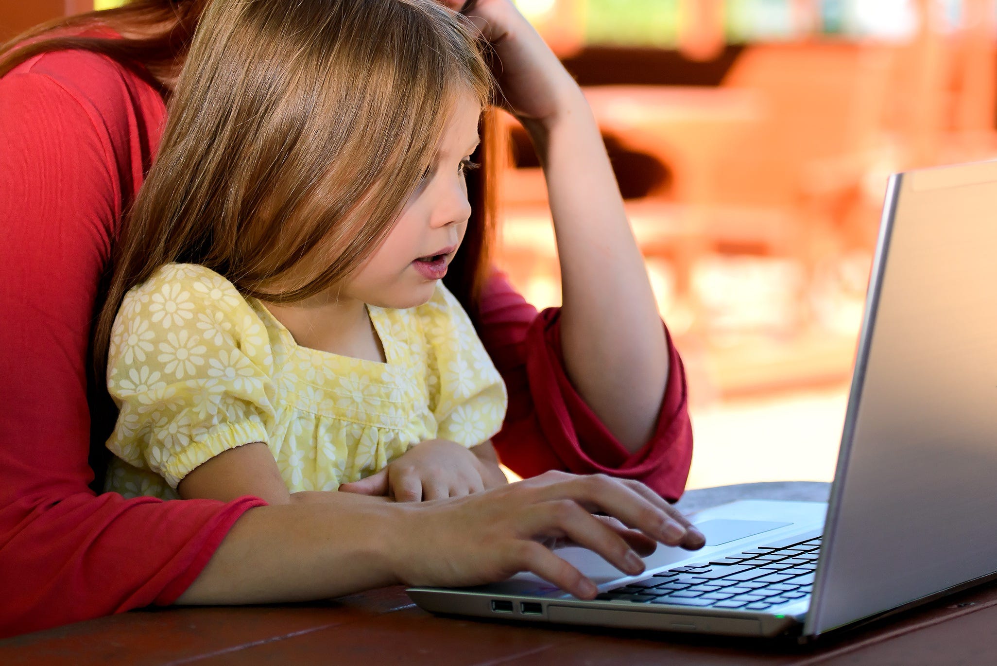 Little girl with mom using a laptop