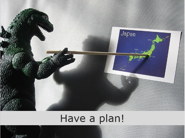 Godzilla puppet dinosaur pointing at a map of Japan