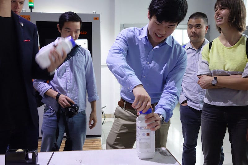 We get a demonstration of an industrial-grade 3D printer. The plastic bottle contains powder to print stainless steel. Image: Peter Bihr (CC by-na-sa)