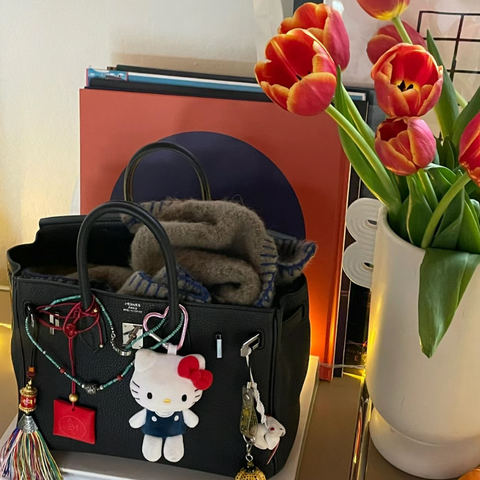 Handbag accessorized with keychains and pendants