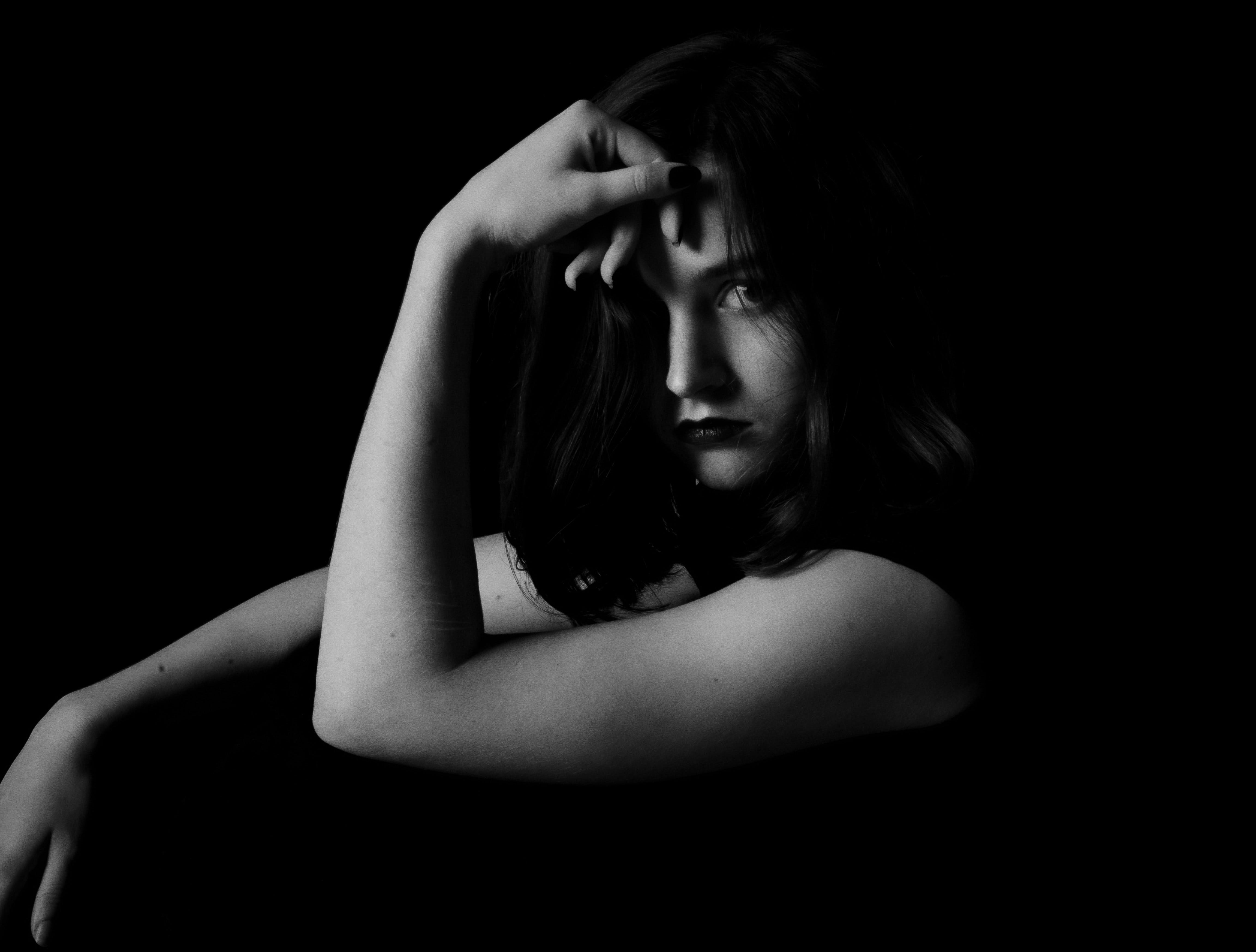 먼 곳을 생각에 잠긴 듯 응시하는 여인의 흑백 사진.