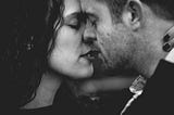 Close up in black and white of a man and woman about to kiss.