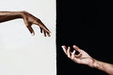 Two arms reaching out to each other. One arm has a white background, while the other has a black background.