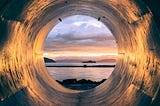 A metal pipe with a view of the ocean