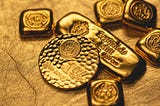 A close up of various rounds and bars of 9999 fine gold from the Scottsdale Mint.