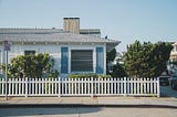 House with white picket fence and blue sky