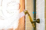 water spraying out of a showerhead, in the style of dark gold and light blue, recycled material murals, body extensions, vibrant color scheme