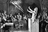 Black and white drawing of woman on the stand during the Salem Witch Trials.