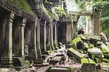 A photo of ancient ruins being enveloped by foliage and time