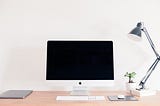 blank computer screen and a keyboard sitting on a desk